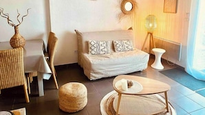 A modern bedroom with a bed, a small table, a chair, a lamp, and a decorative mirror. - Fully-equipped bastidon in the heart of the Ventoux (Aubignan)