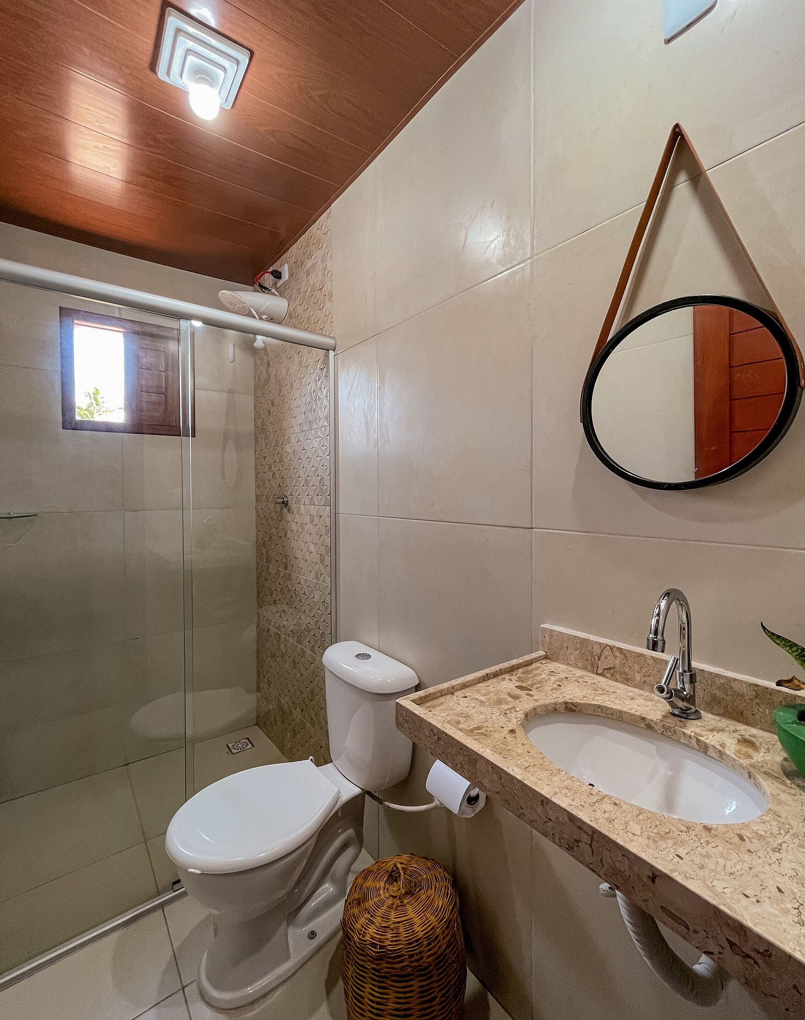 A bathroom with a shower, toilet, and two sinks with a mirror above.