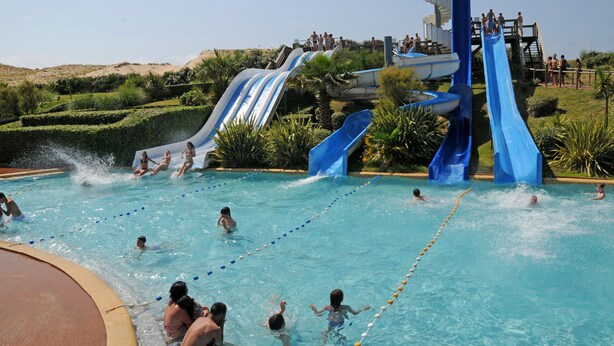 En swimmingpool med flere vandrutsjebaner og en poolterrasse.