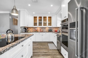 Beautifully updated kitchen with granite tops, shaker cabinetry, induction stove, 2 ovens, toaster oven, Keurig, and drip coffee maker. Service for 8!