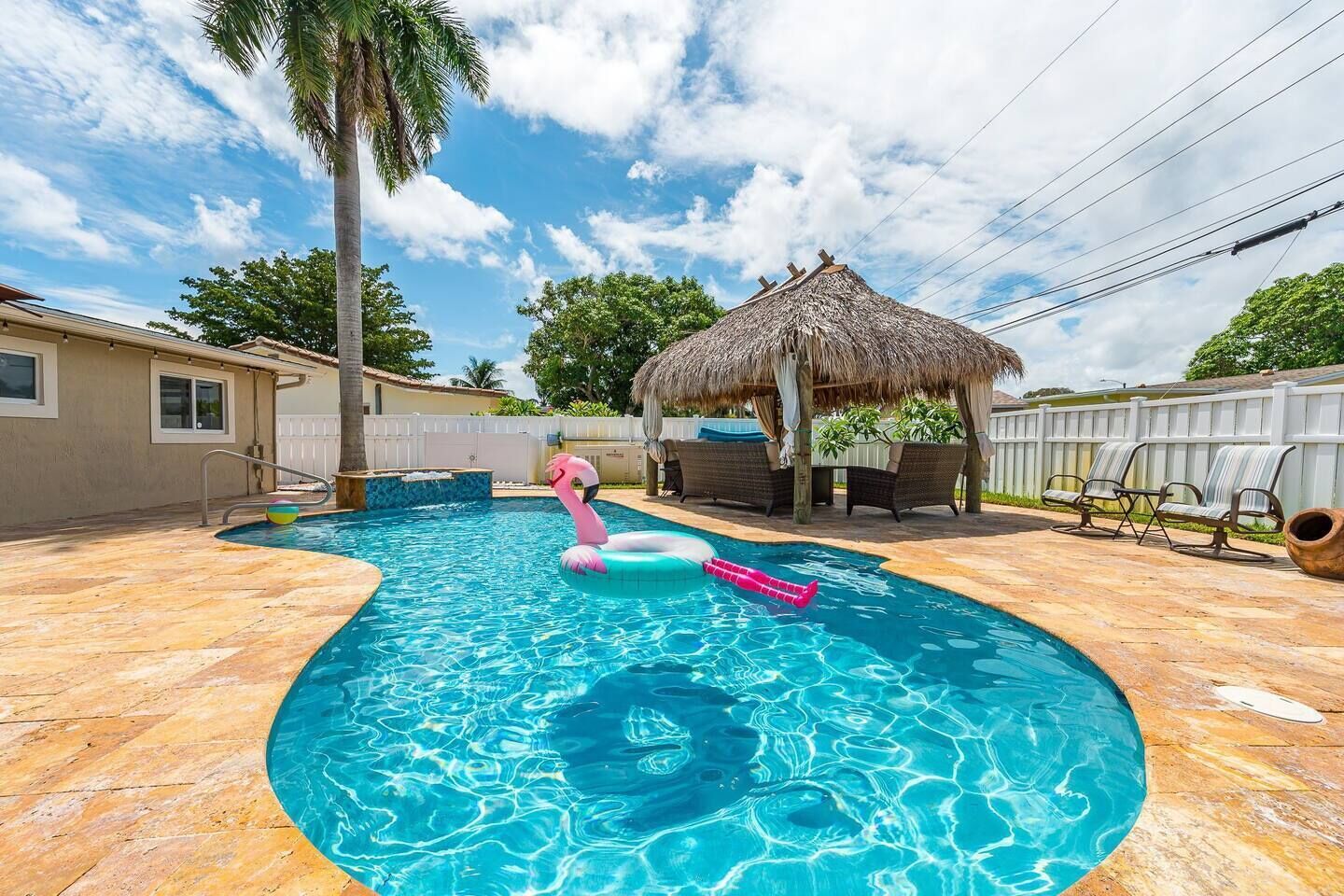 A resort-style oasis in the heart of Deerfield Beach! Large heated saltwater pool with a hot tub, rustic tiki hut with a large gas-powered firepit, string lighting & smart tv. Outdoor dining table for 6 and plenty of seating and lounging for the family.
