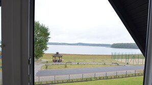 A gazebo in a park with a lake view.