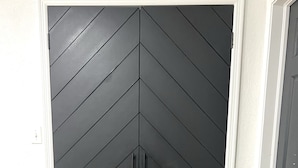 Une porte fermée ornée d’un motif en chevrons.