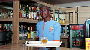 A bar area with shelves stocked with various bottles and a refrigerator in the background. - Montana Guest Resort Naivasha  (Naivasha)