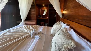 Un dormitorio acogedor con cabecera de madera, cama con ropa de cama blanca y dosel.