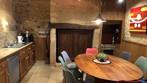 Una cocina rústica con una mesa y sillas de madera, un lavamanos y una estufa.