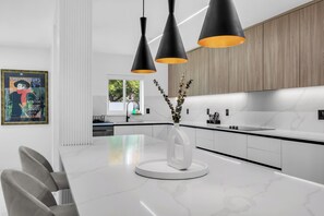 Enjoy cooking in this well-equipped kitchen with a central island, pendant lights, and ample storage.