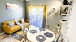 Un salon moderne avec une table à manger ronde, un canapé et un coin cuisine.