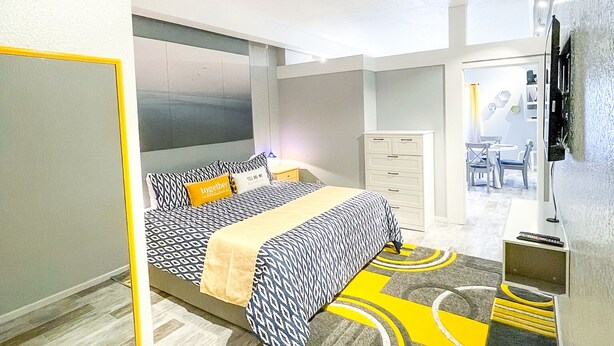Une chambre à coucher moderne avec un lit, des tables de chevet et un téléviseur.