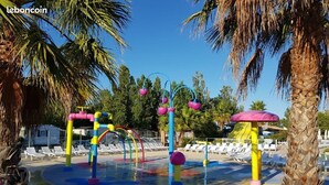 Un parc aquatique doté de jeux colorés et de palmiers.