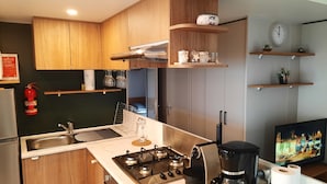 Une cuisine moderne avec des meubles en bois, une cuisinière à gaz, une machine à café et un évier.