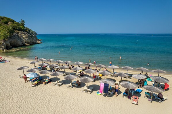 Plage, sable blanc, chaises longues, parasols