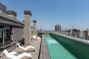 A rooftop pool area with lounge chairs and a view of the cityscape. - Micampus Barcelona Student Residence (Sant Adria de Besos)