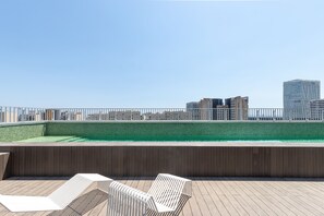 A rooftop pool area with a view of city buildings. - Micampus Barcelona Student Residence (Sant Adria de Besos)