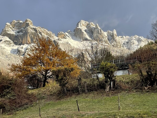 Un paysage montagneux caractérisé par des pics rocheux, un petit pont et une végétation clairsemée.