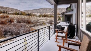 A balcony with a view of a snowy landscape and distant buildings.