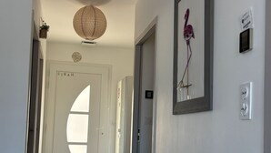 A hallway with a white door, a wall-mounted air purifier, and a framed artwork. - SYRAH Single-Story Villa in a Farming Village in the Gard, Between the Sea and the Cévennes, Air Conditioning, Parking Available (Combas)