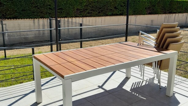 A wooden table with white legs, a wicker chair, and a metal fence in a garden setting. - SYRAH Single-Story Villa in a Farming Village in the Gard, Between the Sea and the Cévennes, Air Conditioning, Parking Available (Combas)