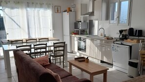 A modern kitchen with a dining area, a sofa, and a bed. - SYRAH Single-Story Villa in a Farming Village in the Gard, Between the Sea and the Cévennes, Air Conditioning, Parking Available (Combas)