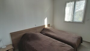 A room with two beds, a nightstand, and a window. - SYRAH Single-Story Villa in a Farming Village in the Gard, Between the Sea and the Cévennes, Air Conditioning, Parking Available (Combas)