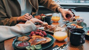 Et morgenbord med et udvalg af mad, blandt andet toast, frugt og et glas appelsinjuice.
