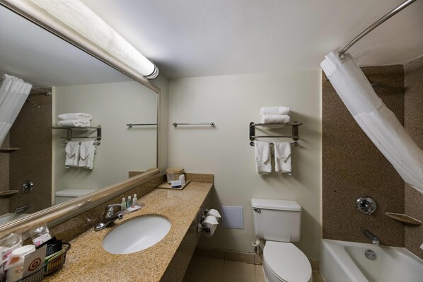 A hotel bathroom with a sink, toilet, and bathtub.