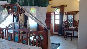 A room with a bed, a desk, and a chair. - Horizon Palace (Zanzibar Town)
