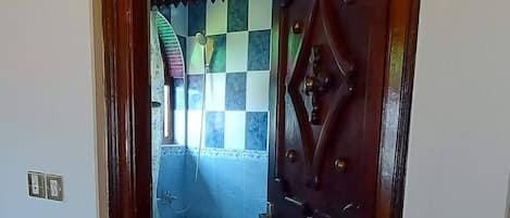 A doorway leading to a bathroom with a tiled floor and a bathtub.