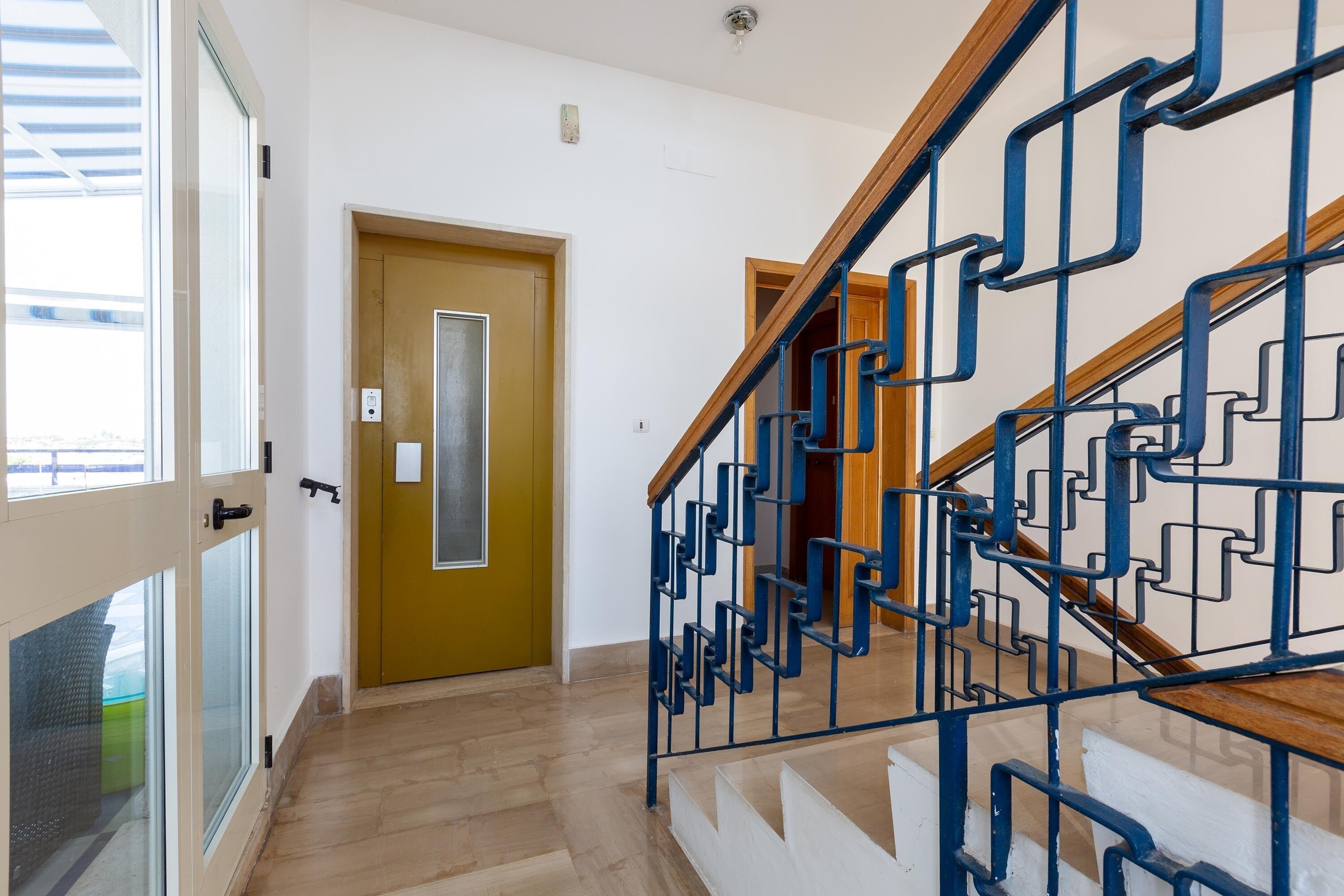 Un escalier avec des rampes en métal bleu et des marches en bois.