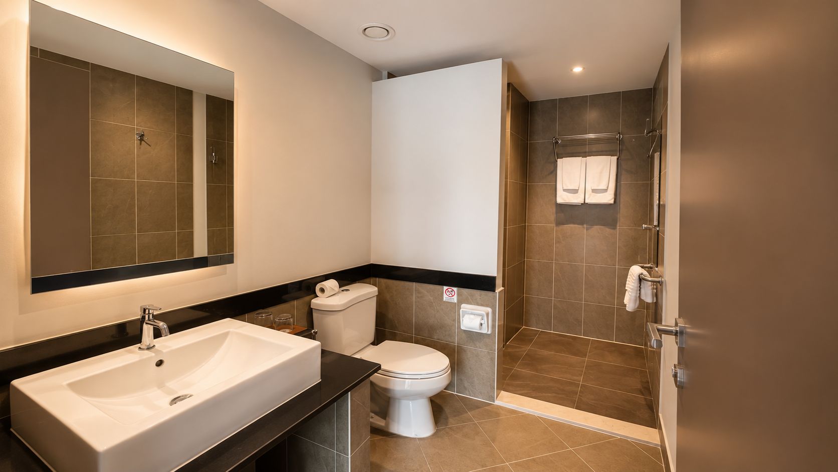 A modern bathroom with a large sink, toilet, and shower area.