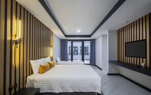 A modern hotel room with a large bed, a TV mounted on the wall, and a balcony with curtains. - Tuana Hotels Casa Del Sol (Karon)