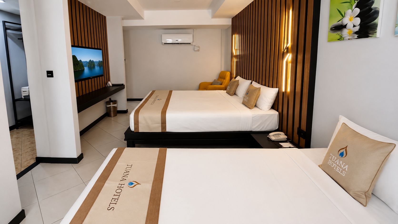 A hotel room with two beds, a TV, and a minibar.