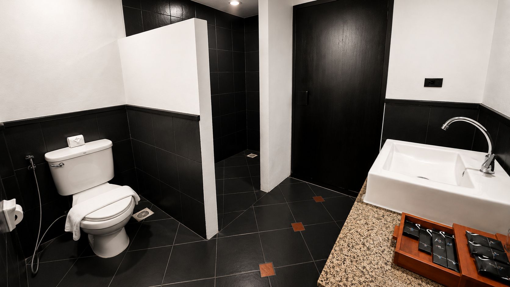 Une salle de bain moderne équipée de toilettes, d’un lavabo et d’un espace douche.