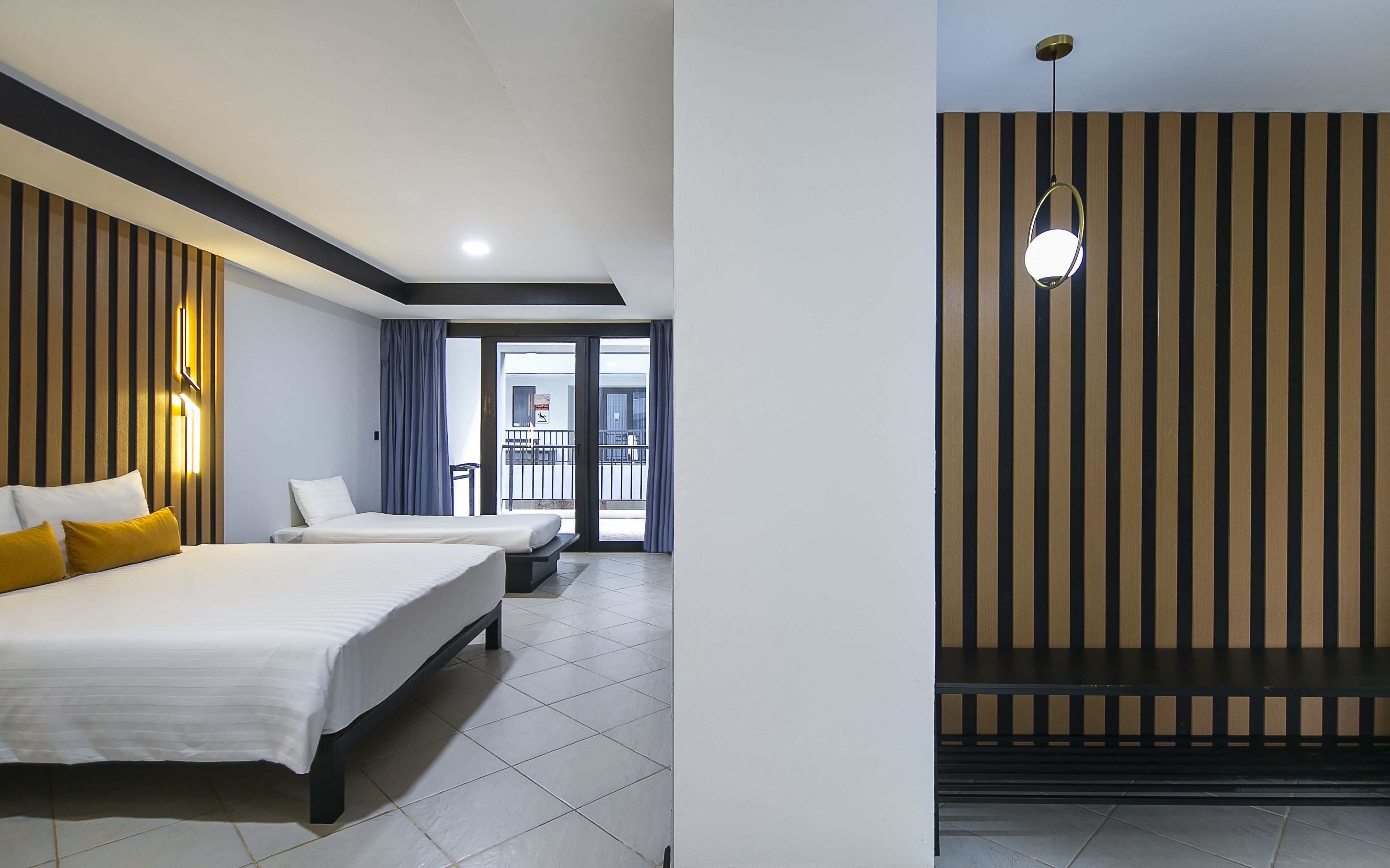 A hotel room with two beds, a balcony, and a modern design.