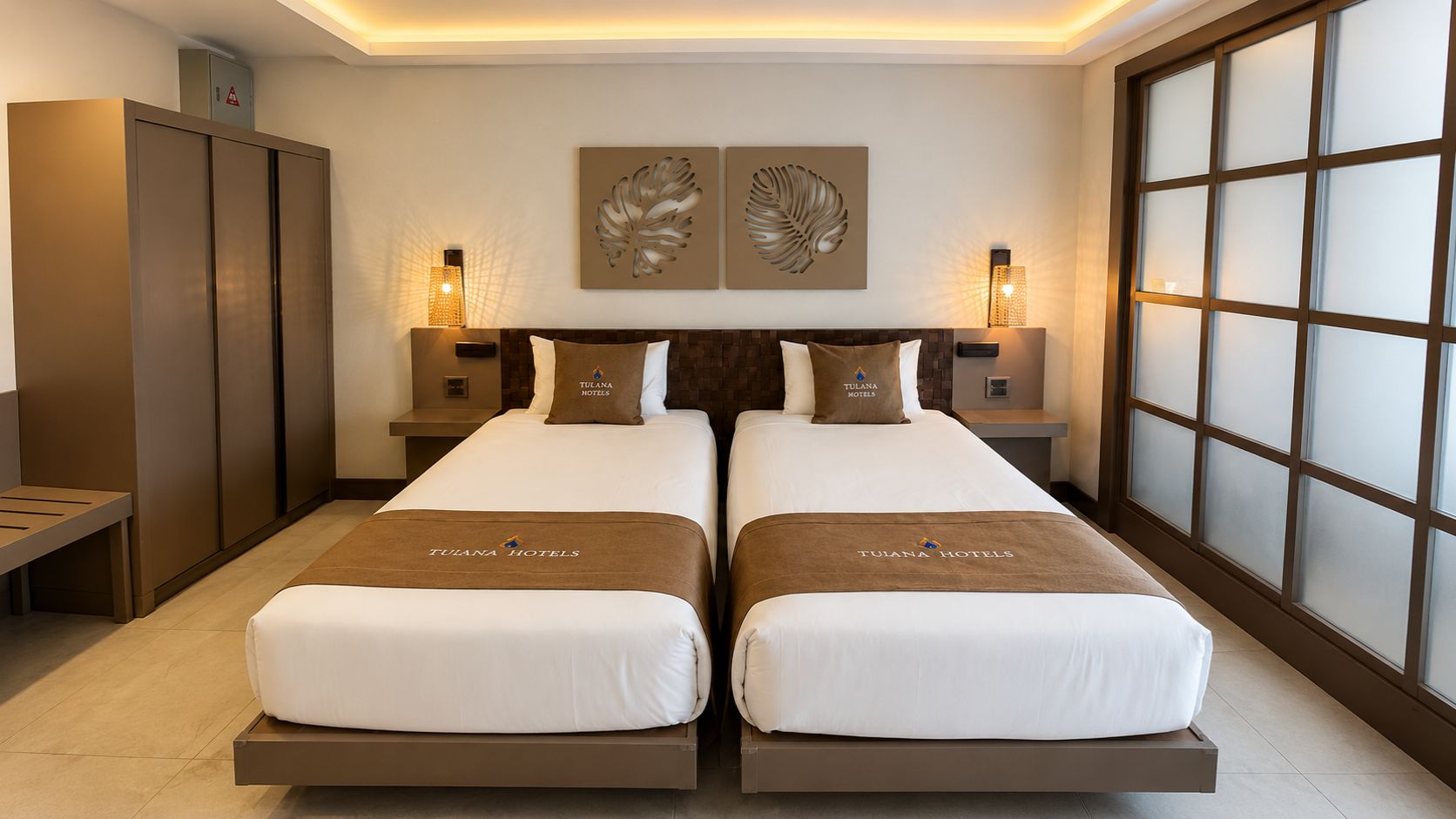 A double bed with two pillows, a nightstand, a wall-mounted lamp, and a window with frosted glass.