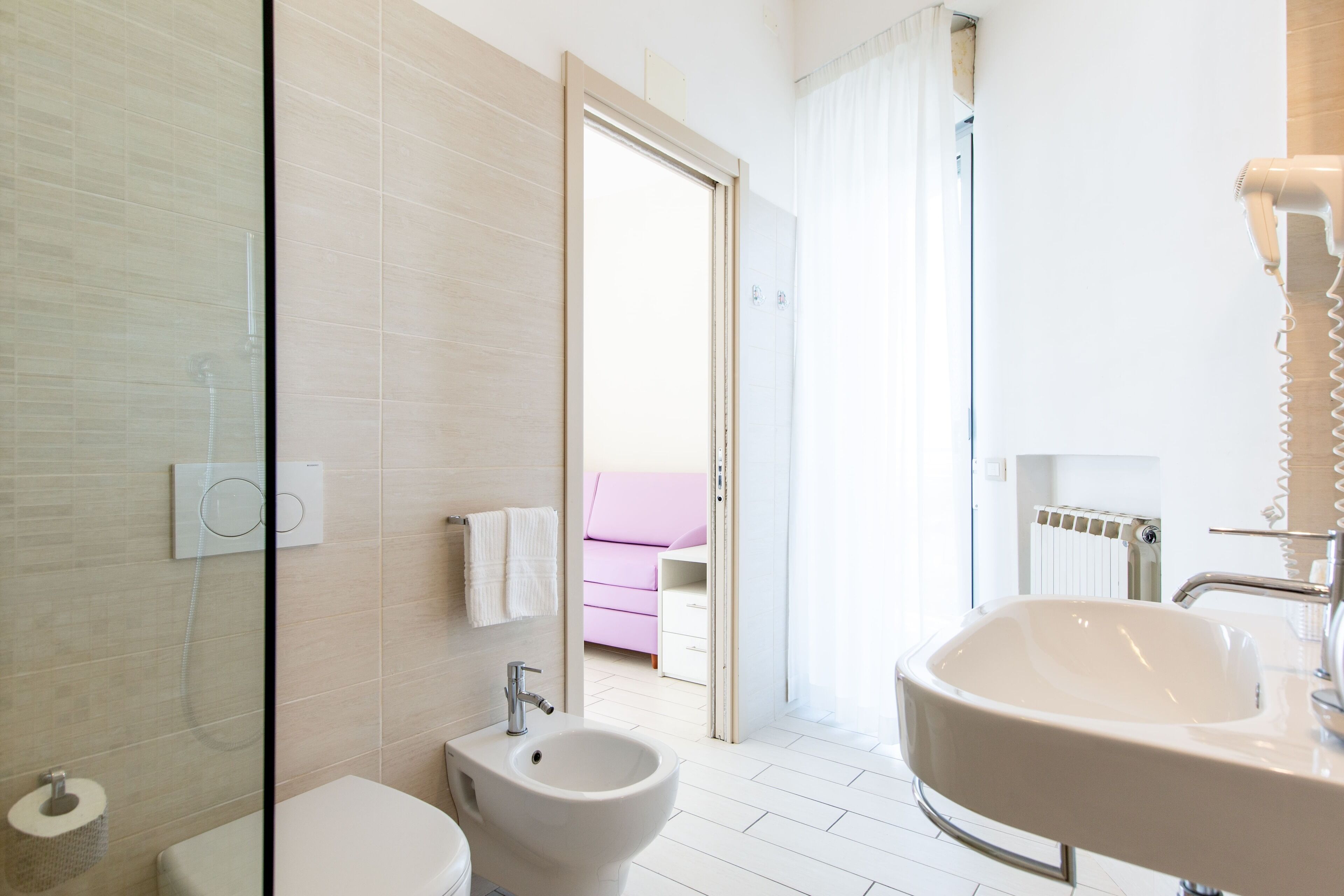 A modern bathroom with a bidet, toilet, and sink.
