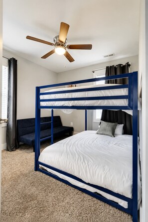 A bunk bed with a ceiling fan, a sofa, and a window with curtains. - 3 BR Home-HUGE yard for petsl4.5 miles to Broadway (Nashville)