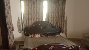 A bedroom with a bed, curtains, a window, and a tiled floor. - Impeccable 4-bed Villa in Mirpur Azad Khasmir (Mirpur)