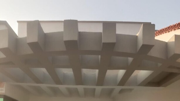 A building entrance with a wooden door, a window with a grid pattern, and a ceiling with a geometric design. - Impeccable 4-bed Villa in Mirpur Azad Khasmir (Mirpur)