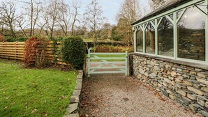A stone house with a green gate leading to a gravel path. - Scandale Bridge Cottage (Ambleside)