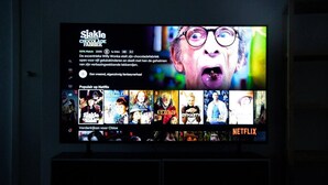 Un televisore mostra un'interfaccia Netflix con diverse miniature di film.