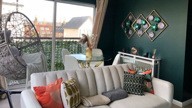 A modern living room with a white sofa, a hanging chair, and a glass table. - Beautiful 1-bed Apartment in Redhill (Redhill)