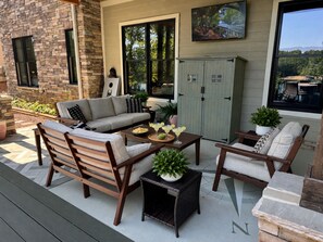 A patio with outdoor furniture, a stone wall, and a view of the landscape.