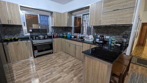 Una cucina moderna con mobili in legno, un piano di lavoro nero e un forno integrato.