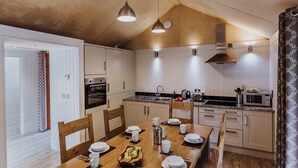 Una cocina moderna con armarios de madera, encimera de granito e iluminación colgante.