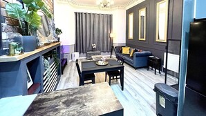 Una sala de estar moderna con chimenea, un conjunto de sofás y una mesa de comedor.