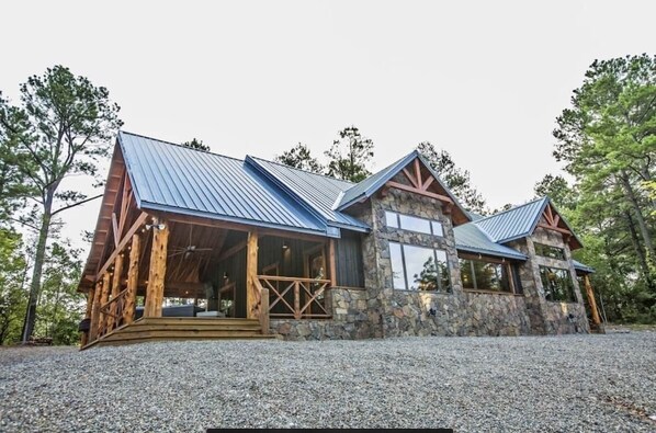 A rustic lodge with a stone facade, wooden beams, and a metal roof.