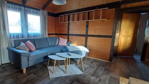 Una habitación acogedora con un sofá azul, una mesita blanca y una lámpara de pie.