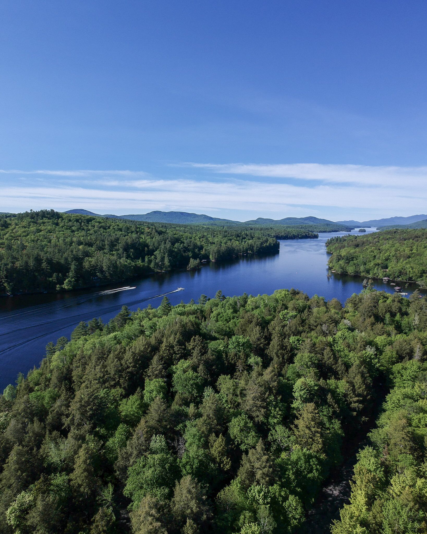 A forested area with a river and boats.