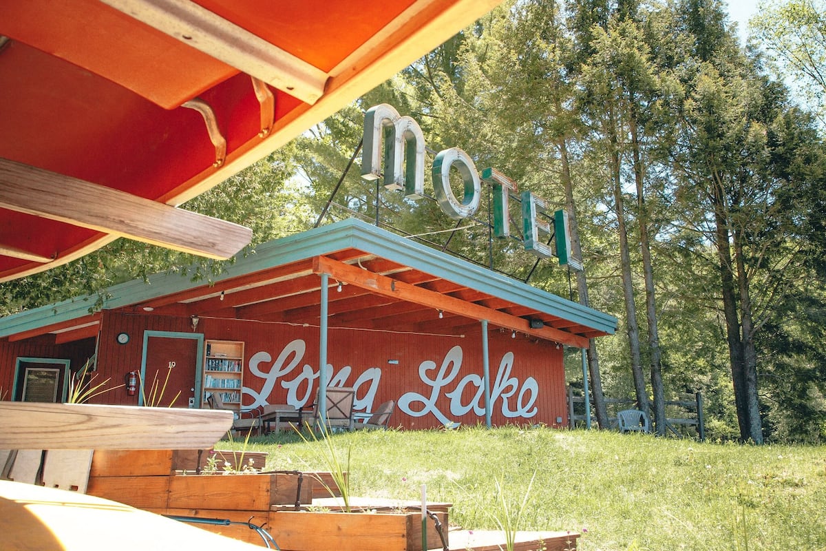 A motel with a rustic exterior, a prominent 'motel' sign, and the name 'Long Lake' on the side.